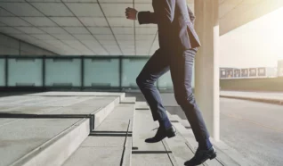 Photo of a person running up steps in a suit