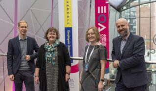Simon, Nicola, Emily and Ewan stood by the railing on the first floor of the Telford events building at the employee ownership association conference