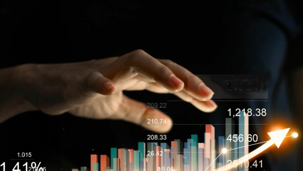 photo of a hand raised over a graphic of stocks and charts