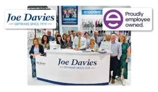 Staff members stood behind a desk with the sign Joe davies infront of it