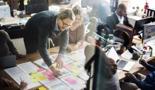 a group of people in an office highlighting pieces of paper