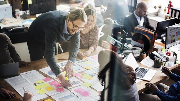 a group of people in an office highlighting pieces of paper