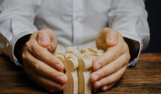 hands cupping a set of wooden figures in their hands