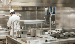 a photo of a person stood in a kitchen cooking with his back to the camera