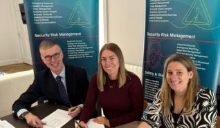 Image of the Inverroy trustees signing papers and smiling at the camera